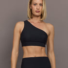Model is wearing Melt One-Shoulder Cropped Tank in Black, front view.