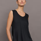Model wears a loosely fitted round neck black tank top.