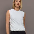 Model is wearing Sleeveless Twist Top in Snow White, front view.