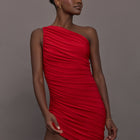 Model wears the Pickleball Diana Dress in Tiger Red, featuring a sleeveless, asymmetrical design with a fitted bodice