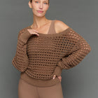 Model is wearing wide neck open knit sweater in caribou, front close-up view.
