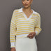 Model wears a lightweight collared open knit yellow and white striped sweater. 