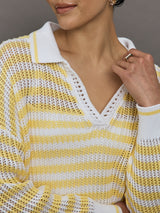 Model wears a lightweight collared open knit yellow and white striped sweater. 