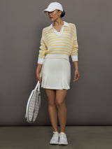 Model wears a lightweight collared open knit yellow and white striped sweater. 