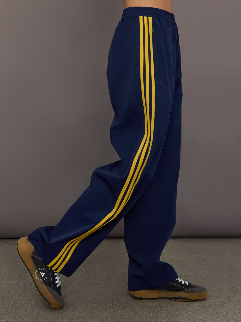 Side view of the Miaou pant in collegiate navy highlighting the relaxed straight leg fit and contrast yellow stripe detailing.