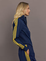 Side profile of the Miaou tracktop in collegiate navy highlighting contrast stripe sleeves and a structured cropped cut.