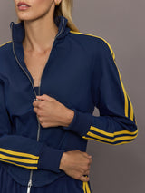 Close up of the Miaou tracktop in collegiate navy featuring the zip front high collar and contrast stripe sleeves.