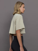 Model wears cropped t-shirt with a boxy fit, dropped shoulders, and a mock neck.
