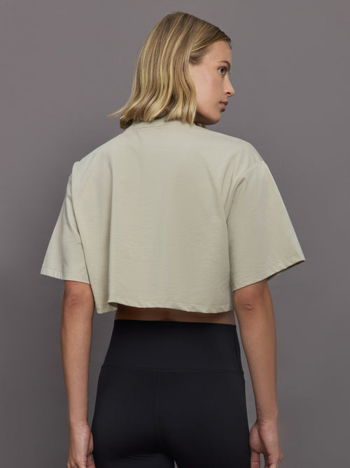 Model wears cropped t-shirt with a boxy fit, dropped shoulders, and a mock neck.
