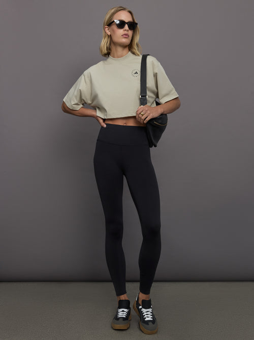 Model wears cropped t-shirt with a boxy fit, dropped shoulders, and a mock neck.
