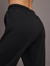Model is wearing black jogger sweatpants with drawstring and pockets