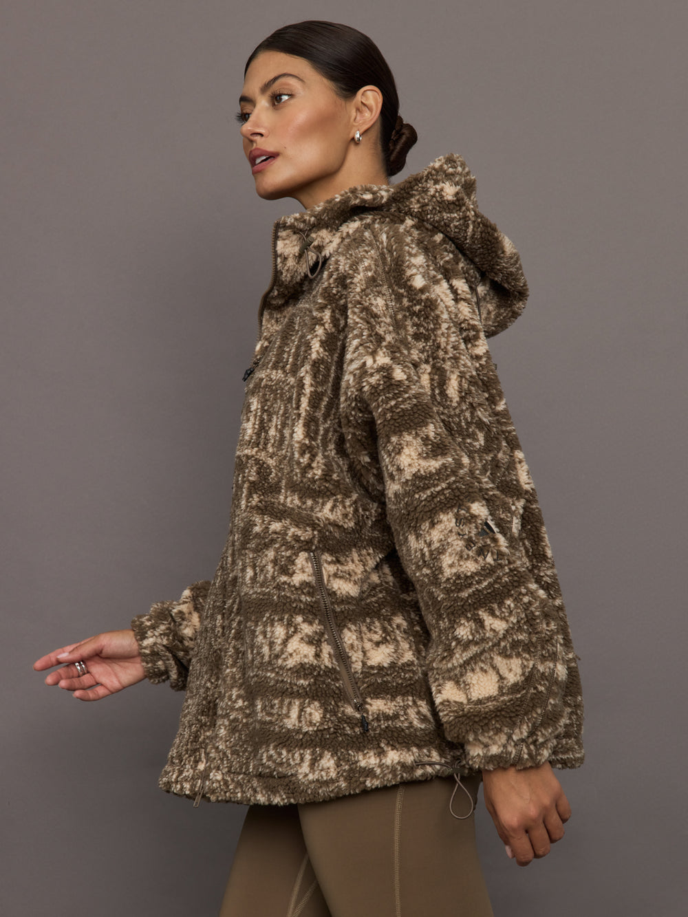 Woman wearing a patterned jacket against a gray background