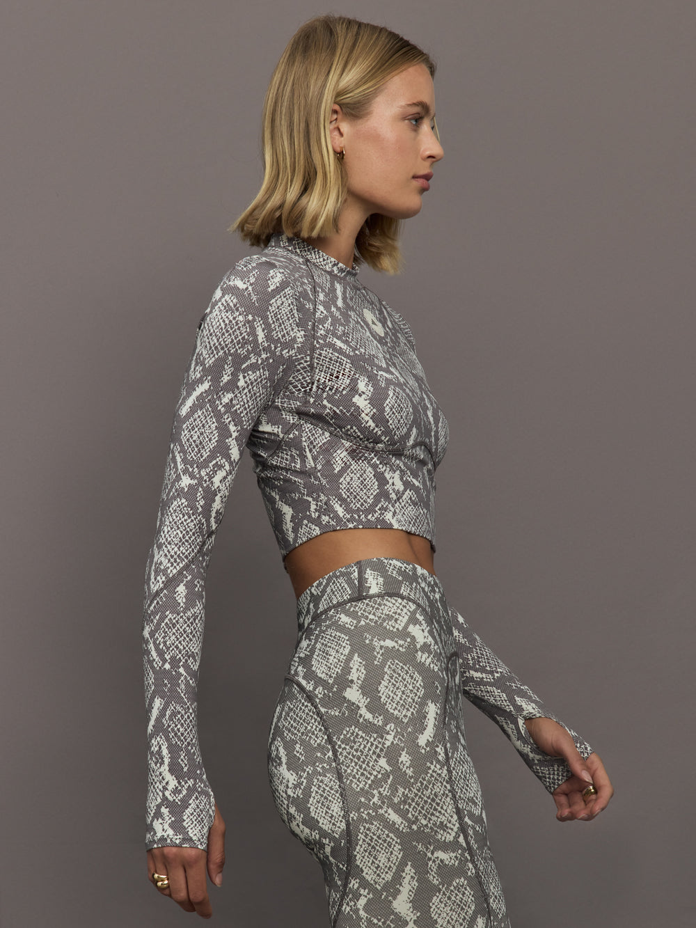 Model wearing grey and white snake print long-sleeve top.