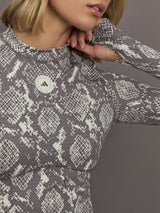 Model wearing grey and white snake print long-sleeve top.