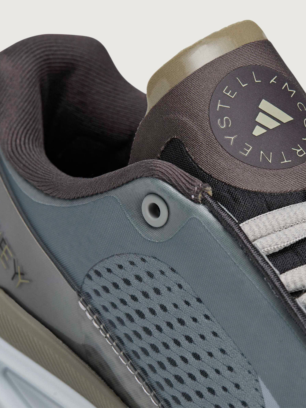 Close-up of a sneaker with a visible brand logo on a light gray background