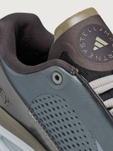 Close-up of a sneaker with a visible brand logo on a light gray background