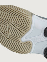 Close-up of a shoe sole with tread pattern and brand name on a light gray background