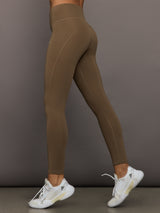 Brown leggings worn by a person on a gray background