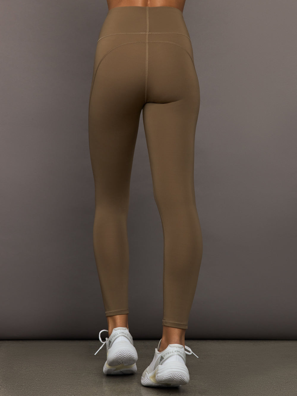 Brown leggings worn by a person on a gray background