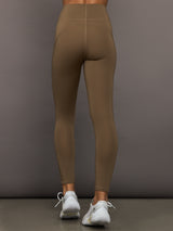 Brown leggings worn by a person on a gray background