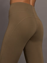 Brown leggings worn by a person on a gray background
