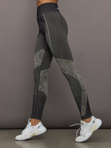 Dark gray leggings with patterned design worn by a person on a plain background