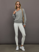 Model wearing a white sports bra with Adidas logo.