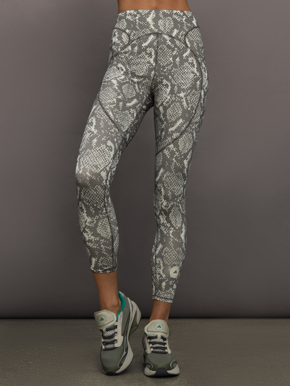 Model wearing grey and white snake print leggings.
