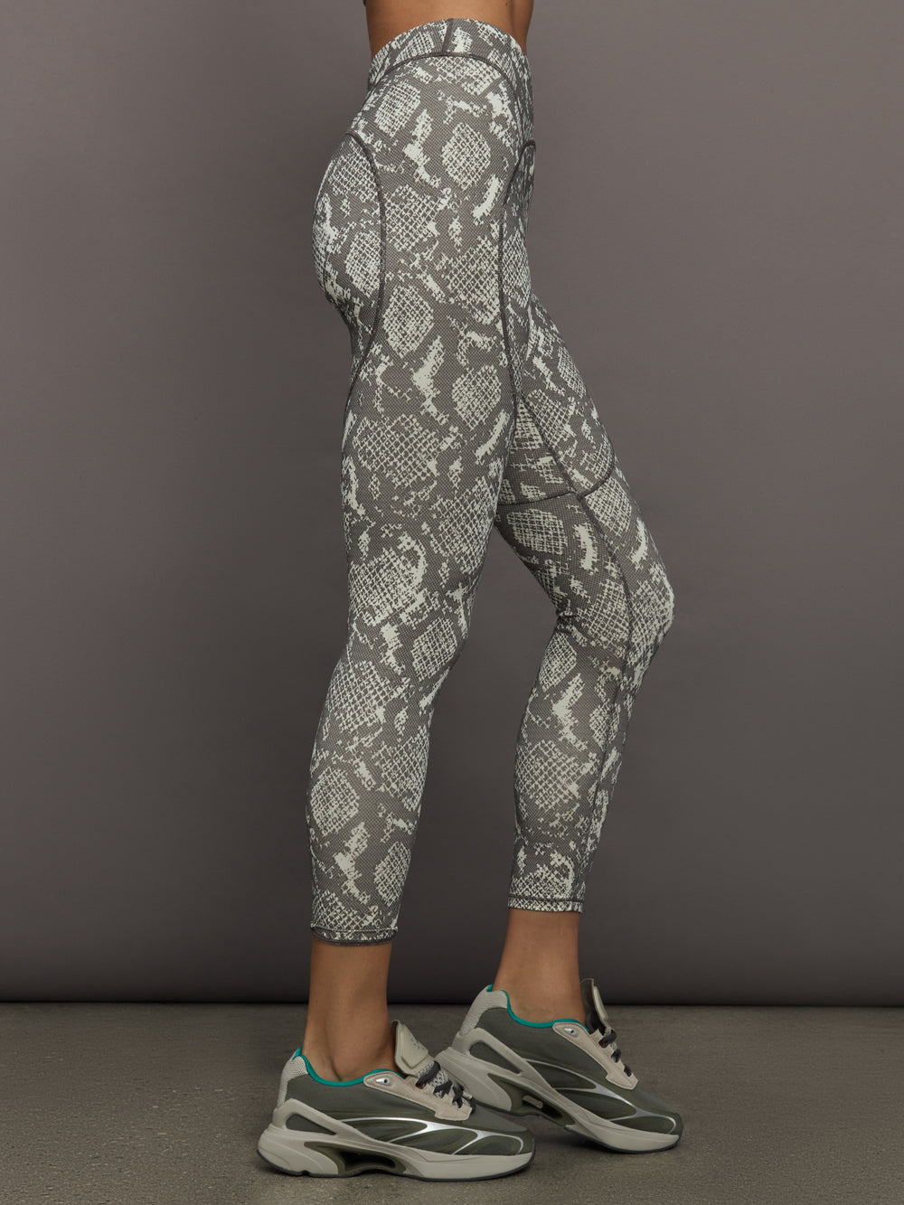 Model wearing grey and white snake print leggings.