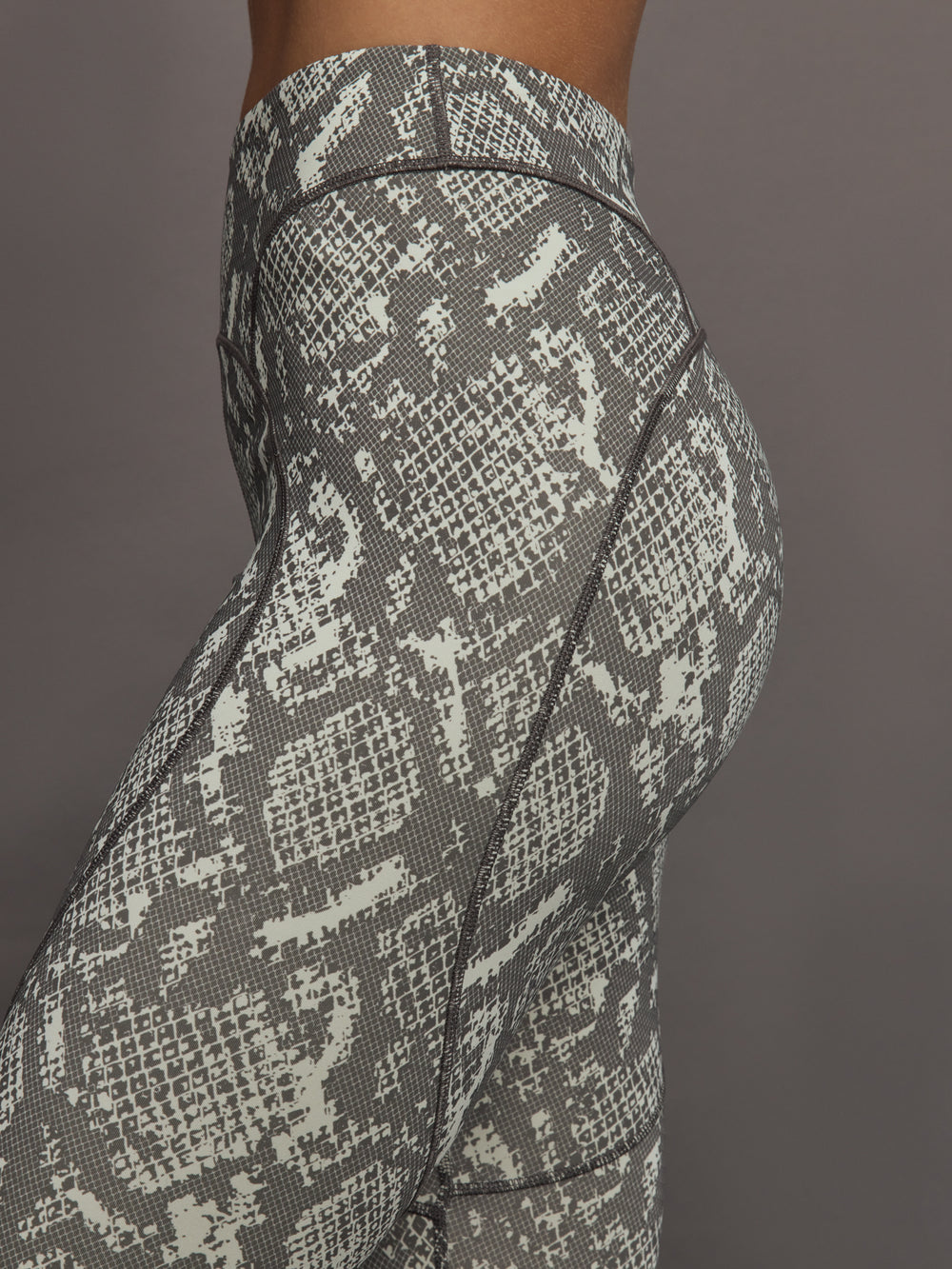 Model wearing grey and white snake print leggings.