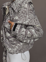 Model wears an almond/charcoal patterned jacket.