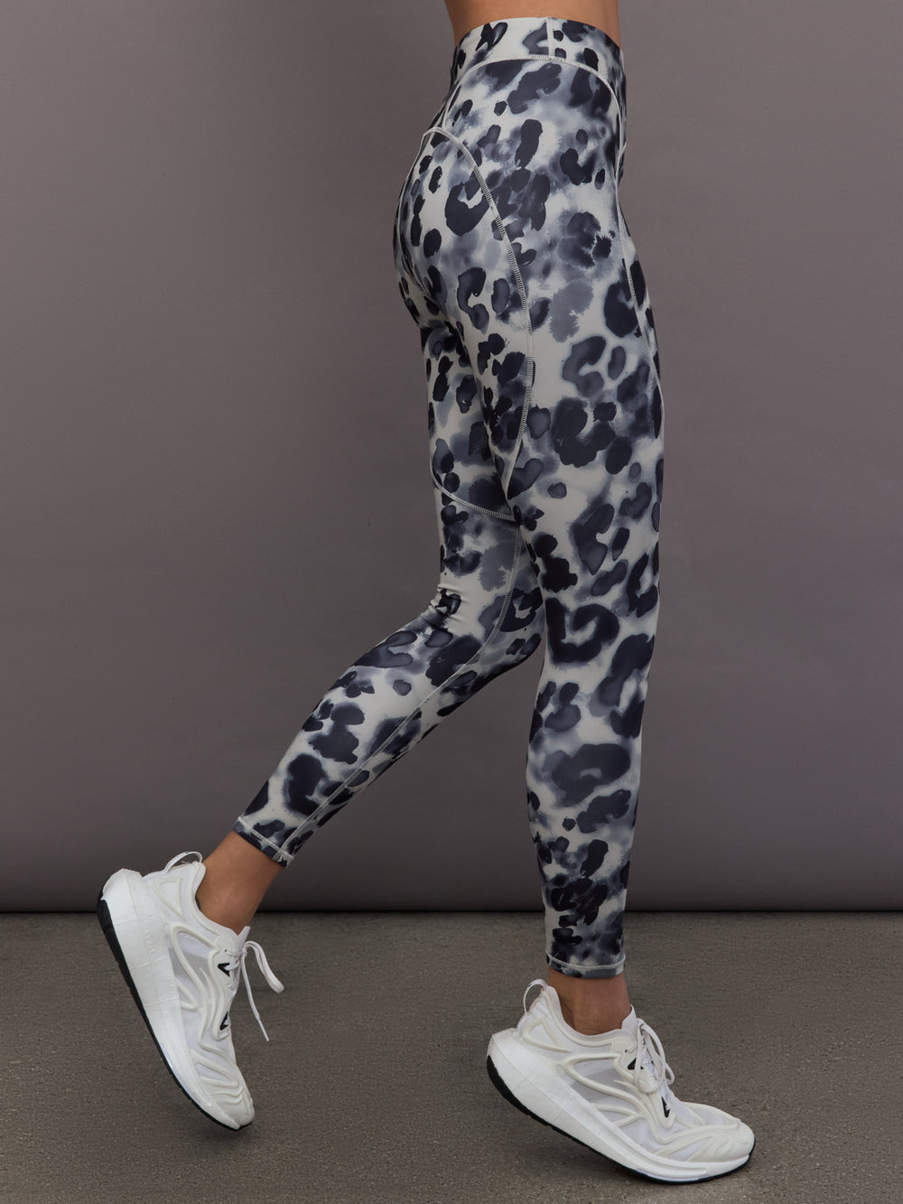 Model is wearing Training Interlock High-Waisted 7/8 Legging in Wonder Alumina/Black, side profile view.