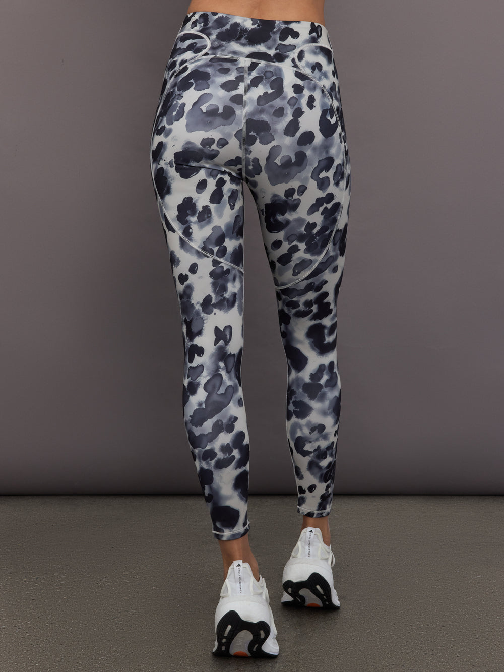 Model is wearing Training Interlock High-Waisted 7/8 Legging in Wonder Alumina/Black, back view.
