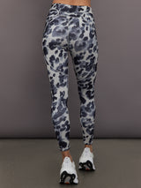 Model is wearing Training Interlock High-Waisted 7/8 Legging in Wonder Alumina/Black, back view.
