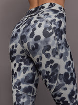 Model is wearing Training Interlock High-Waisted 7/8 Legging in Wonder Alumina/Black, close-up seam and fabric detail.