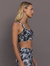 Model is wearing Power Interlock Medium-Support Sports Bra in Wonder Alumina/Black, side profile view.
