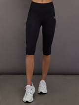 Model is wearing Yoga Interlock High-Waisted Capri Legging in Black, front leg detail view.