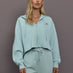 Model is wearing Sportswear Cropped Zip Hoodie in Vapour Green, front view.