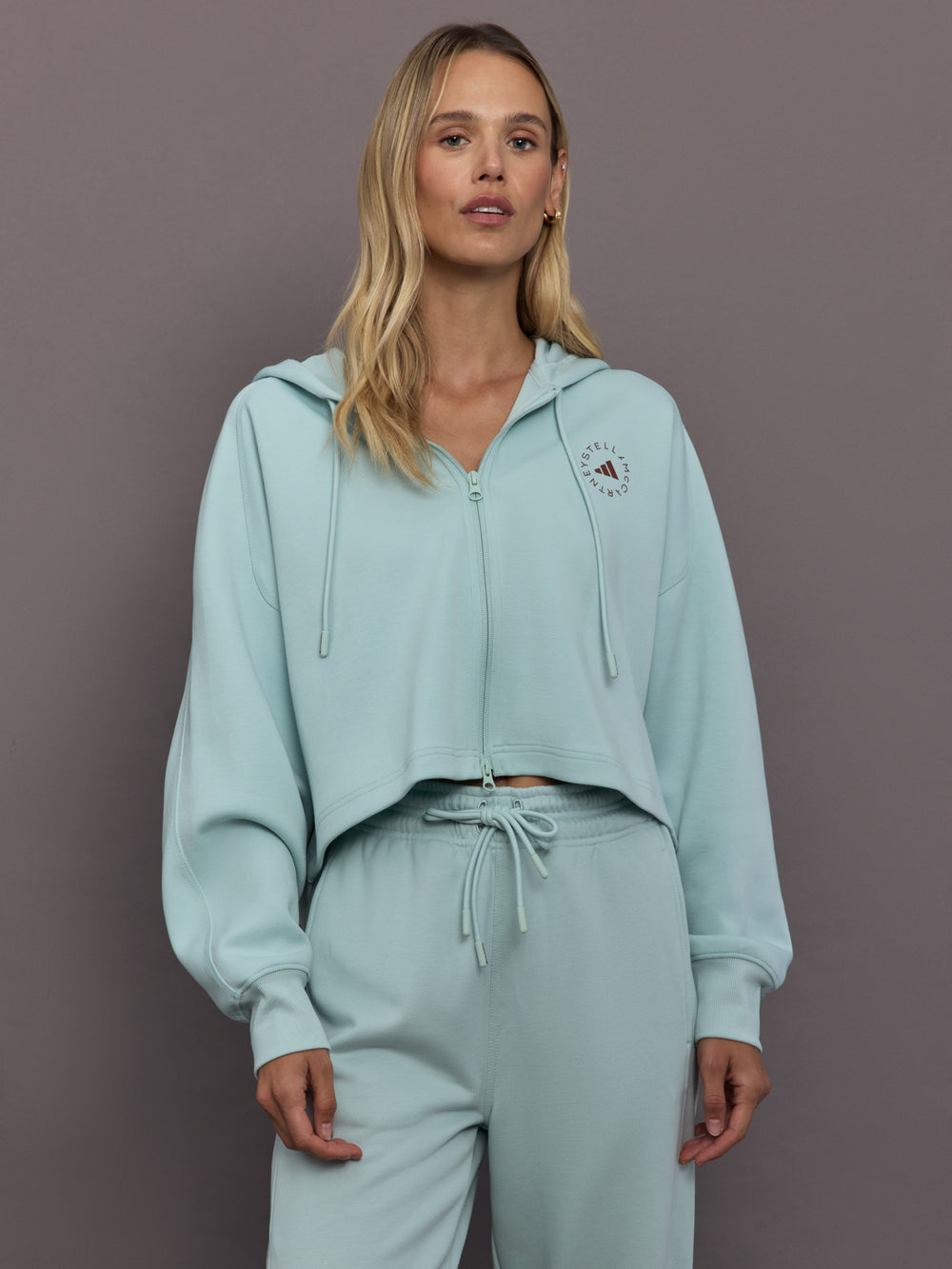 Model is wearing Sportswear Cropped Zip Hoodie in Vapour Green, front view.