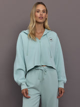 Model is wearing Sportswear Cropped Zip Hoodie in Vapour Green, front view.