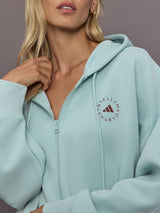 Model is wearing Sportswear Cropped Zip Hoodie in Vapour Green, logo detail close-up.