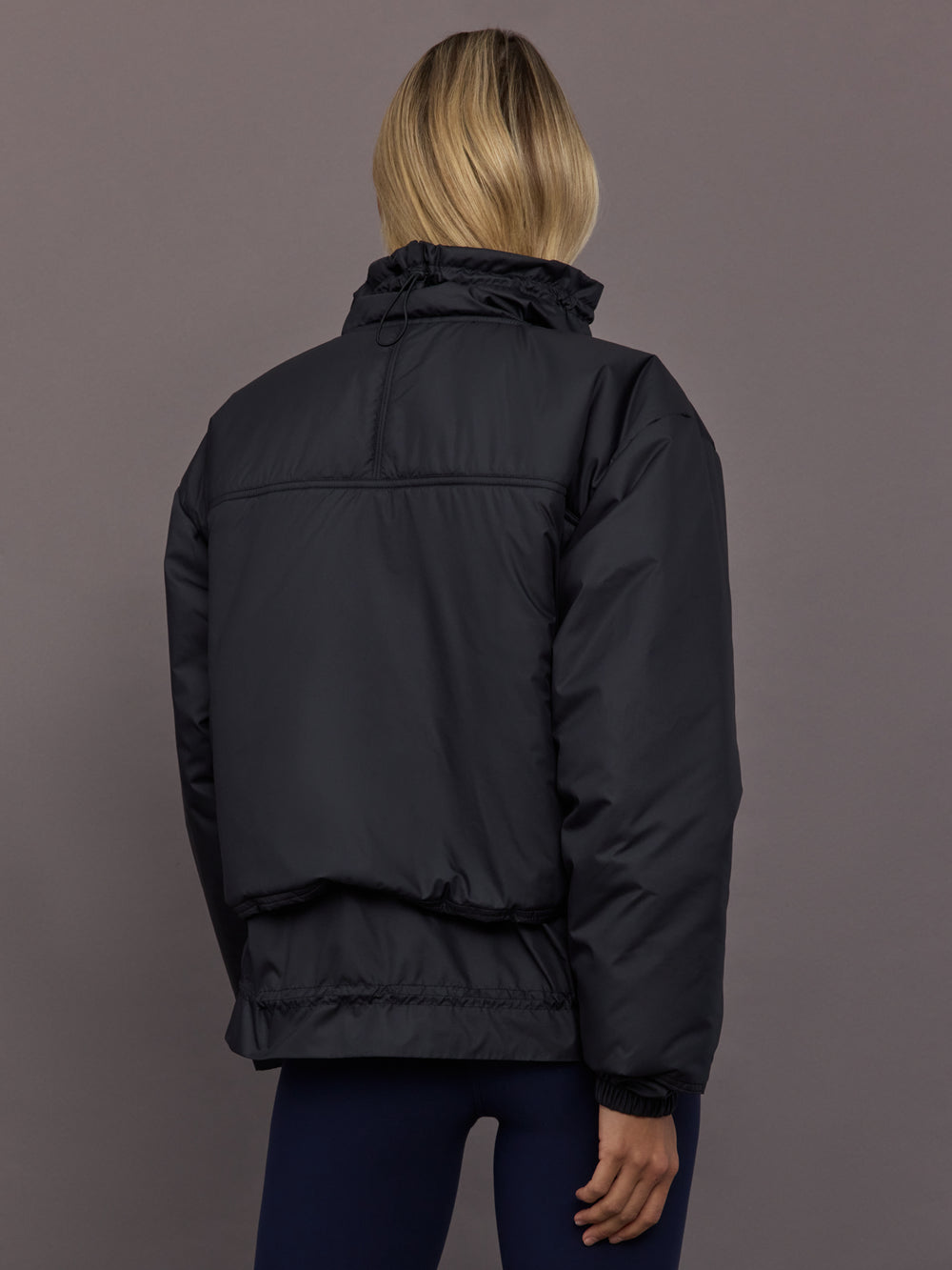Model is wearing Liner Water-Resistant Jacket in black, back view.