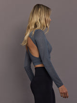 Model is wearing Lace Tricot Open-Back Crop Top in Onix, side profile view.