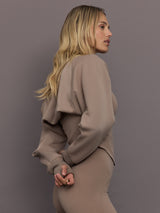 Model is wearing Studio Double Knit Cropped Shrug in Chalky Brown, side profile view.