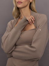 Model is wearing Studio Double Knit Cropped Shrug in Chalky Brown, close-up ribbed cuff and neckline detail.