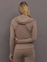 Model is wearing Studio Ruched Half-Zip Top in Chalky Brown, back view.