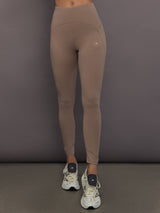 Model is wearing Studio Ruched High-Rise Legging in Chalky Brown, front view.