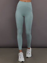 Model is wearing Studio Ruched High-Rise Legging in Wonder Sage, front view.