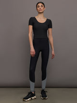 Model wears a cropped black scoopneck short sleeve top.
