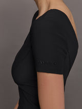 Model wears a cropped black scoopneck short sleeve top.